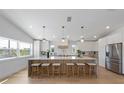 Bright kitchen features a large island with seating, modern lighting, and stainless steel appliances at 616 Fern St, Anna Maria, FL 34216