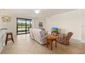 Spacious living room featuring tile floors, a ceiling fan, and sliding glass doors leading to the outside at 6923 Grand Estuary Trl # 101, Bradenton, FL 34212