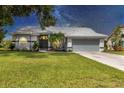 Charming single-story home with a well-maintained lawn, complemented by fresh landscaping and neutral tones at 6929 Stetson Street Cir, Sarasota, FL 34243