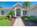 Home's inviting entrance features manicured landscaping, decorative planters, and a walkway to the front door at 7302 Dunes Ct, Bradenton, FL 34202