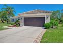 Attached two-car garage with a concrete driveway and lush landscaping add convenience and curb appeal at 7302 Dunes Ct, Bradenton, FL 34202