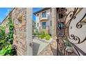 View through the iron gate showcases the home's stone exterior, balconies, and landscaped courtyard at 795 Marbury Ln, Longboat Key, FL 34228