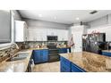 Well-equipped kitchen with granite countertops, stainless steel appliances, and stylish blue and white cabinets at 8804 Founders Cir, Palmetto, FL 34221
