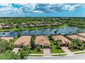 Scenic aerial view of a community with homes bordering a tranquil lake and lush greenery at 8820 Heritage Sound Dr, Bradenton, FL 34212