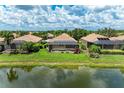 Aerial view showcases screened-in lanais overlooking a serene pond, surrounded by landscaped backyards at 8820 Heritage Sound Dr, Bradenton, FL 34212