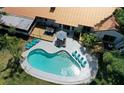 Aerial view of a backyard with a large pool, wooden deck, patio furniture, and lush landscaping at 1112 Montezuma Dr, Bradenton, FL 34209