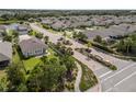 Aerial view of home in a beautiful neighborhood featuring mature landscaping and a community lake at 11434 Spring Gate Trl, Bradenton, FL 34211