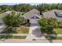 Aerial view of a well-maintained single-Gathering home featuring lush landscaping and a brick paved driveway at 11434 Spring Gate Trl, Bradenton, FL 34211