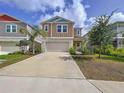 Inviting two-story home boasts a manicured front lawn, two-car garage, and a vibrant blue sky backdrop at 12832 Oak Hill Way, Parrish, FL 34219