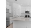 Modern kitchen with white cabinets, stainless steel appliances, and quartz countertops at 16652 Bergamo Pl, Bradenton, FL 34211