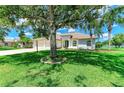 Inviting curb appeal with lush lawn and mature trees in front of home with a three car garage at 208 147Th Ne St, Bradenton, FL 34212
