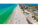 Expansive beachfront view showcasing pristine white sands, turquoise waters, and nearby residential buildings at 2513 Avenue B # B, Bradenton Beach, FL 34217