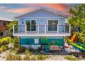 Exterior view of blue beach house with porch at 2513 Avenue B # B, Bradenton Beach, FL 34217