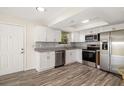 Modern kitchen with stainless steel appliances, white cabinets, granite countertops, and wood-look floors at 2513 Avenue B # B, Bradenton Beach, FL 34217