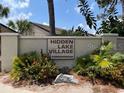 Community sign for Hidden Lake Village Condominiums, surrounded by lush greenery at 2636 Hidden Lake N Dr # G, Sarasota, FL 34237