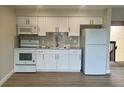 Bright kitchen featuring white cabinetry, stone countertops, and stainless steel appliances at 2636 Hidden Lake N Dr # G, Sarasota, FL 34237