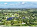 Expansive aerial view of the property featuring lush greenery, ponds, and the property line at 3045 Logue Rd, Myakka City, FL 34251