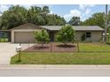 Exterior shot of a single-story home with tan paint, fenced yard and mature landscaping at 3240 6Th St, Sarasota, FL 34237