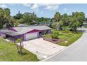 Charming single-story purple home featuring a spacious driveway, well-maintained lawn, and lush landscaping at 3240 6Th St, Sarasota, FL 34237