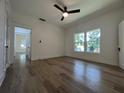 Bright bedroom featuring hardwood floors, a ceiling fan, and two large windows allowing ample natural light at 3429 37Th N St, St Petersburg, FL 33713