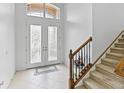 Bright foyer with tile flooring, staircase, and decorative glass double doors leading to the home's entry at 3671 Summerwind Cir, Bradenton, FL 34209