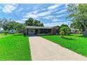 Inviting single-Gathering home featuring a well-maintained lawn and long driveway leading to the front entrance at 444 Flamingo Dr, Apollo Beach, FL 33572