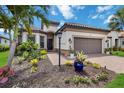 Beautiful home exterior with manicured landscaping, vibrant flowers, brick paver driveway, and attached two-car garage at 4540 Terrazza Ct, Bradenton, FL 34211