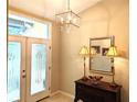 Inviting foyer with decorative glass doors, stylish chandelier, and elegant furnishings at 4733 Spring Meadow Ln, Sarasota, FL 34233