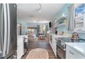 Open-concept kitchen with stainless steel appliances overlooks a cozy living area at 509 Pine Ave # A, Anna Maria, FL 34216