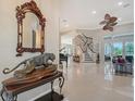 Grand foyer boasting glossy tile floors, a curved staircase, and ornate decor with views into the living spaces at 520 Rye Ne Rd, Bradenton, FL 34212