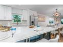 Well-lit eat-in kitchen with white cabinets and counters, a large island, and stylish modern decor at 5600 Beach Way Dr # 315, Sarasota, FL 34242