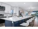 Modern eat-in kitchen with stainless appliances, white cabinets, a large island, and waterfront views at 5600 Beach Way Dr # 315, Sarasota, FL 34242