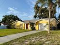 A single-story home with a well-kept lawn, a paved driveway, a red front door, and a white garage door at 5615 Waneta Pl, Sarasota, FL 34231