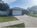 A single-story home featuring an attached two-car garage and a well-maintained lawn at 5848 Milton Ave, Sarasota, FL 34243