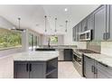 Modern kitchen featuring stainless steel appliances, a center island, tiled backsplash, and stylish pendant lighting at 6423 Royal Tern Cir, Lakewood Ranch, FL 34202