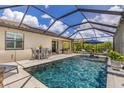 A luxurious screened-in pool features lounge chairs, dining, and open skies at 6507 Clairborne Ln, Bradenton, FL 34211