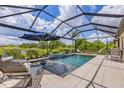 Relaxing screened-in pool area, complete with lounge chairs, umbrella, and private water view at 6507 Clairborne Ln, Bradenton, FL 34211