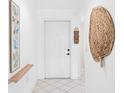 Bright condo foyer with tile flooring, and a white front door with charming coastal décor at 6507 Stone River Rd # 304, Bradenton, FL 34203