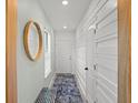 Inviting entryway featuring a round mirror and modern wainscoting at 6563 Silverstar Dr, Sarasota, FL 34240