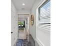 Bright entryway featuring a stylish bench, modern mirror, and natural light from a window at 6563 Silverstar Dr, Sarasota, FL 34240