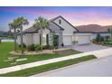 Lovely one story home showcasing stone details, a tile roof, beautiful landscaping, and a 3-car garage at 7228 Great Egret Blvd, Sarasota, FL 34241