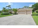 Charming home featuring a well-manicured lawn, lush landscaping, and a spacious three-car garage at 7464 Ridge Rd, Sarasota, FL 34238