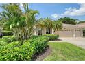 Charming home featuring a well-manicured lawn, lush landscaping, and a spacious three-car garage at 7464 Ridge Rd, Sarasota, FL 34238