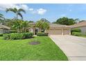 Charming home featuring a well-manicured lawn, lush landscaping, and a spacious three-car garage at 7464 Ridge Rd, Sarasota, FL 34238
