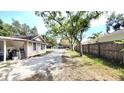View of the driveway leading to a house with wood siding and a covered parking area behind a gated fence at 809 30Th E Ave, Bradenton, FL 34208