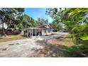 View of the driveway leading to a house with wood siding and a covered parking area behind a gated fence at 809 30Th E Ave, Bradenton, FL 34208
