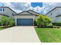 Charming single Gathering home showcasing a blue garage door and well-manicured landscaping at 8721 Firefly Pl, Parrish, FL 34219