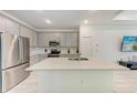 Modern kitchen featuring white cabinets, stainless steel appliances and light countertops at 8721 Firefly Pl, Parrish, FL 34219