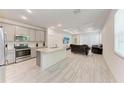Open-concept living room featuring a sleek kitchen island and a plush couch at 8721 Firefly Pl, Parrish, FL 34219