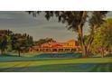 Sprawling clubhouse with a red tiled roof, surrounded by lush greenery and mature trees at 912 Ponderosa Pine Ln, Sarasota, FL 34243